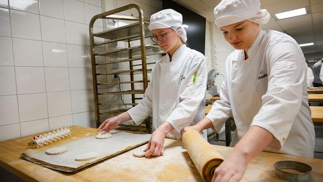 Opiskelijat Anna Mäenpää ja Karoliina Maukonen valmistavat leipiä myyntiin Safkabiilin.